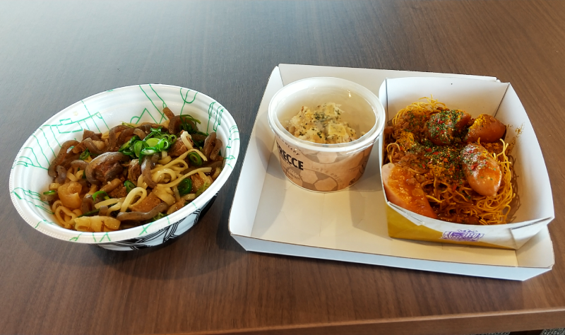 『アジャメン』のぼっかけ麺(左)と『サンチェのジャーマンデリカ』のケバブポテトサラダとソーカレー(フライドヌードル)